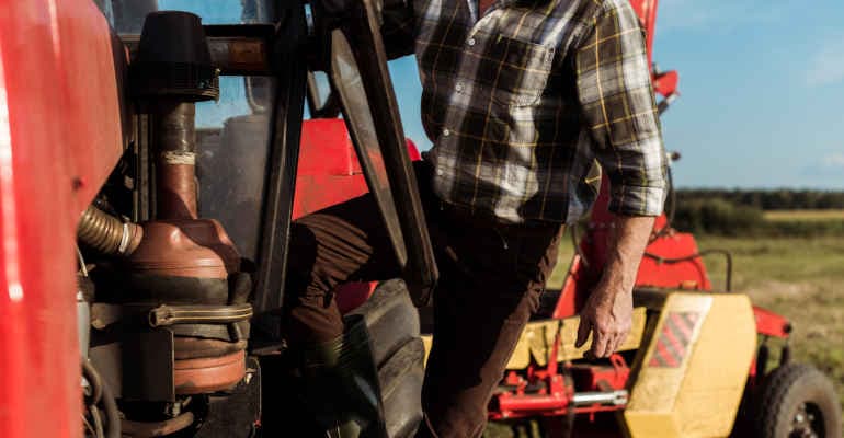 dettaglio agricoltore che scende dal trattore