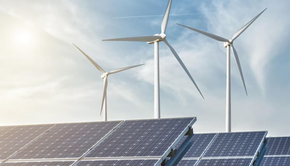 Pale eoliche e pannelli solari sullo sfondo del cielo e sole.