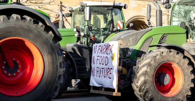 trattore con cartello di protesta